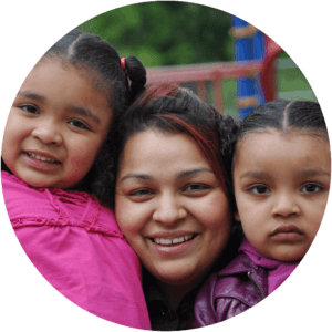 hispanic mom and two young daughters smiling